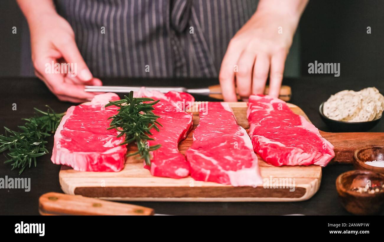 Raw New York strip steaks on a wood cutting board Stock Photo Alamy