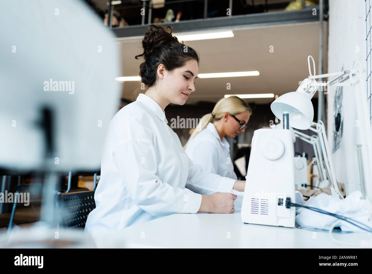 Women using sewing machines at factory Stock Photo