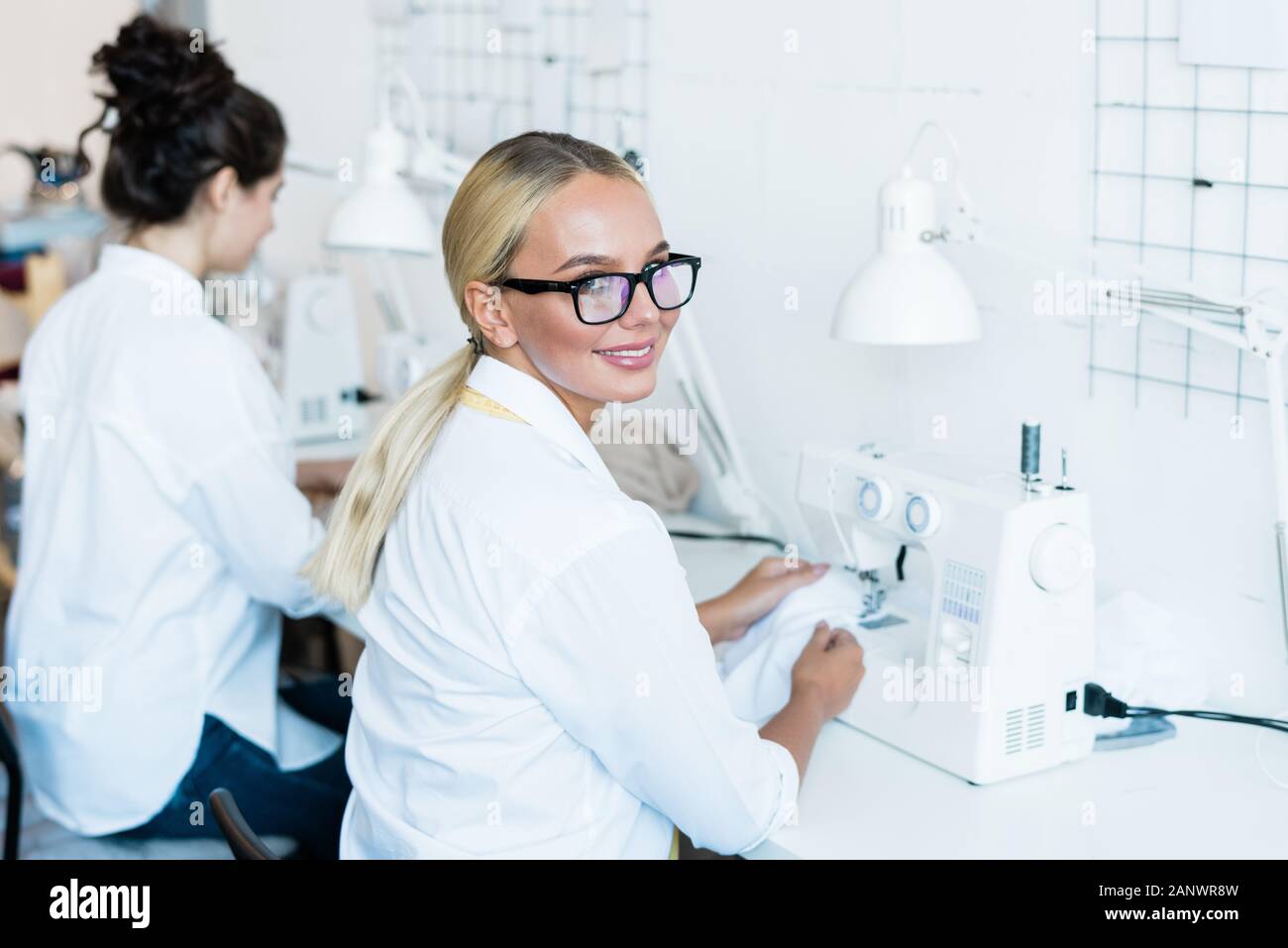 Blond woman at sewing machine Stock Photo