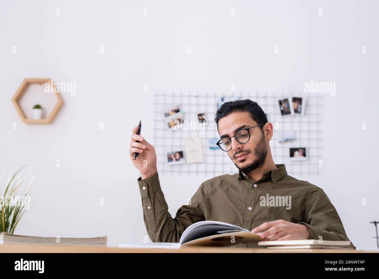 Young male student with open book looking through study materials Stock Photo