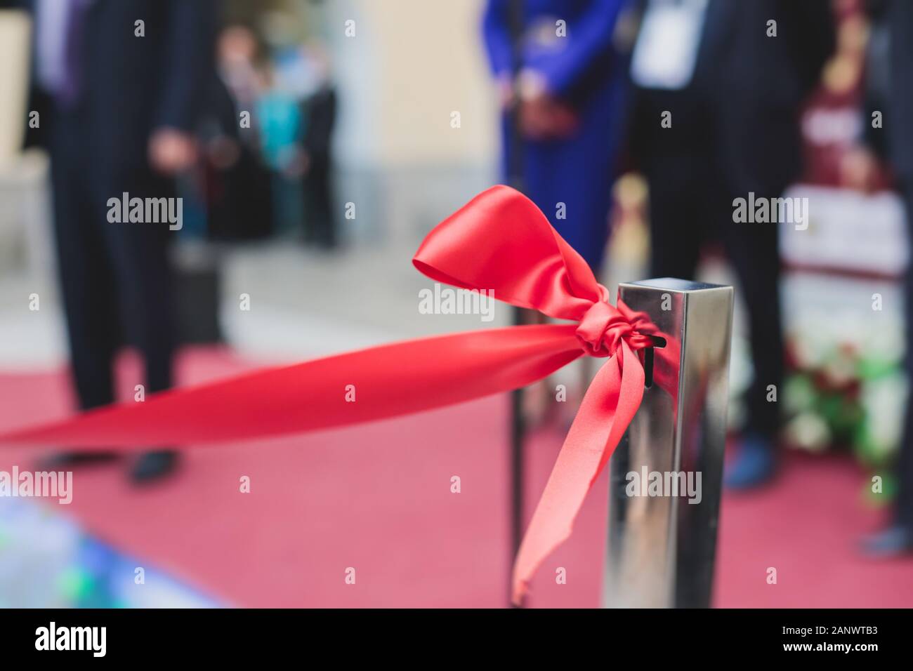 Process of cutting the red ribbon during the grand opening of the new