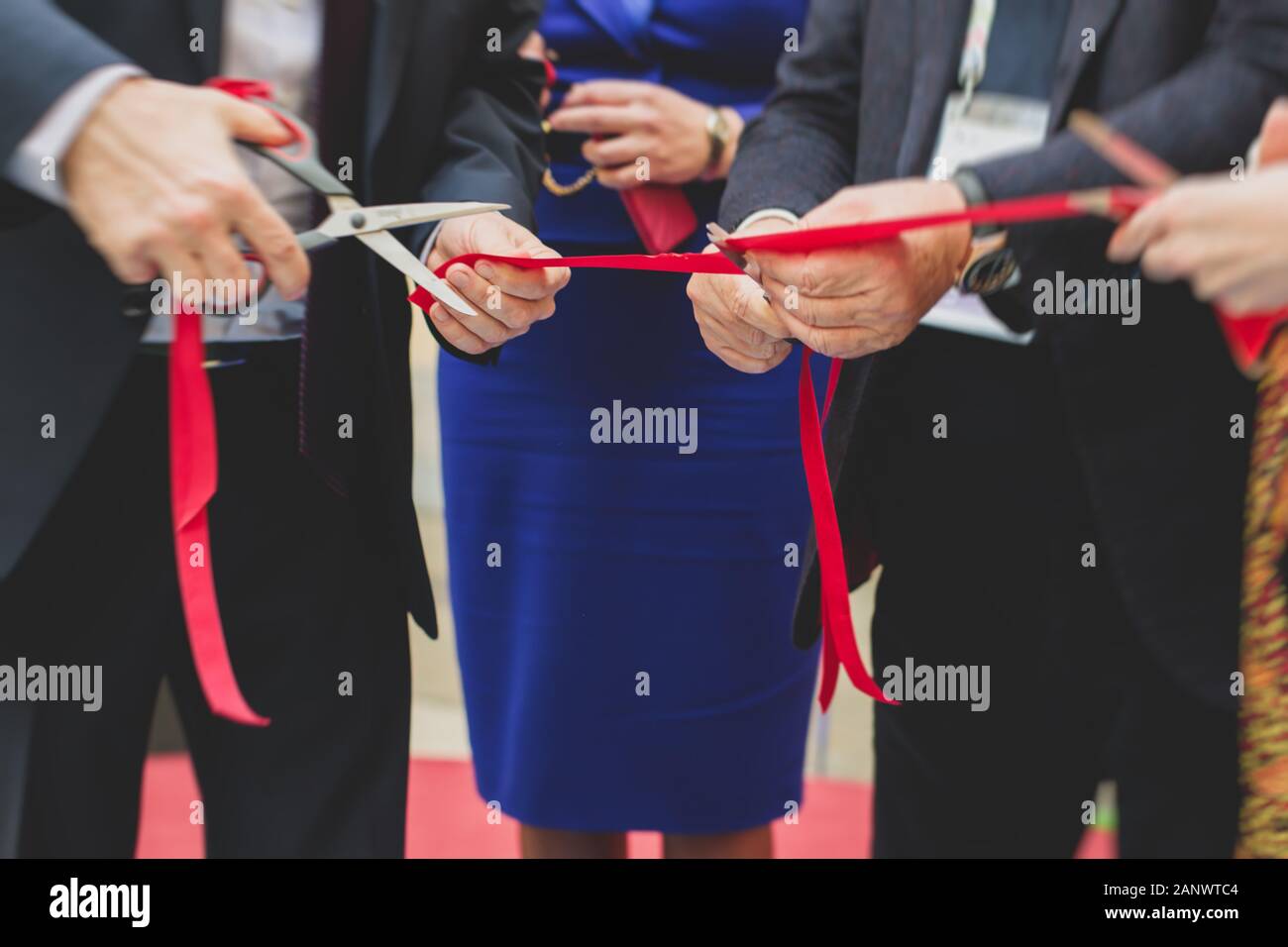 Process of cutting the red ribbon during the grand opening of the new