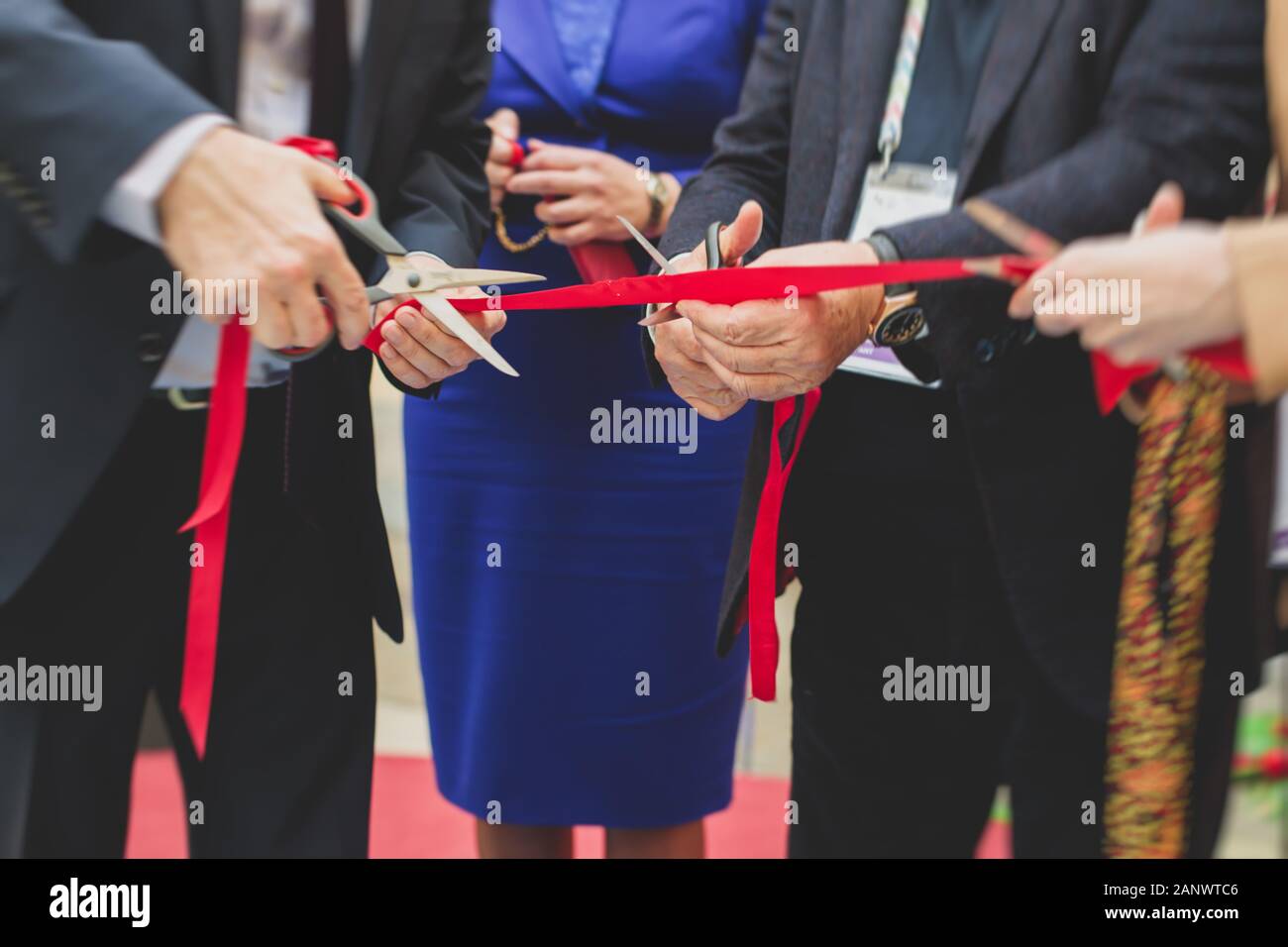 Process of cutting the red ribbon during the grand opening of the new