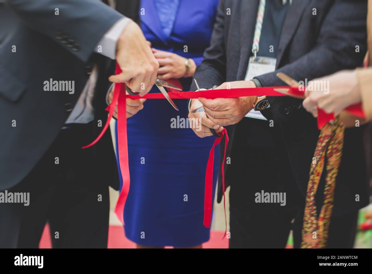 Process of cutting the red ribbon during the grand opening of the new