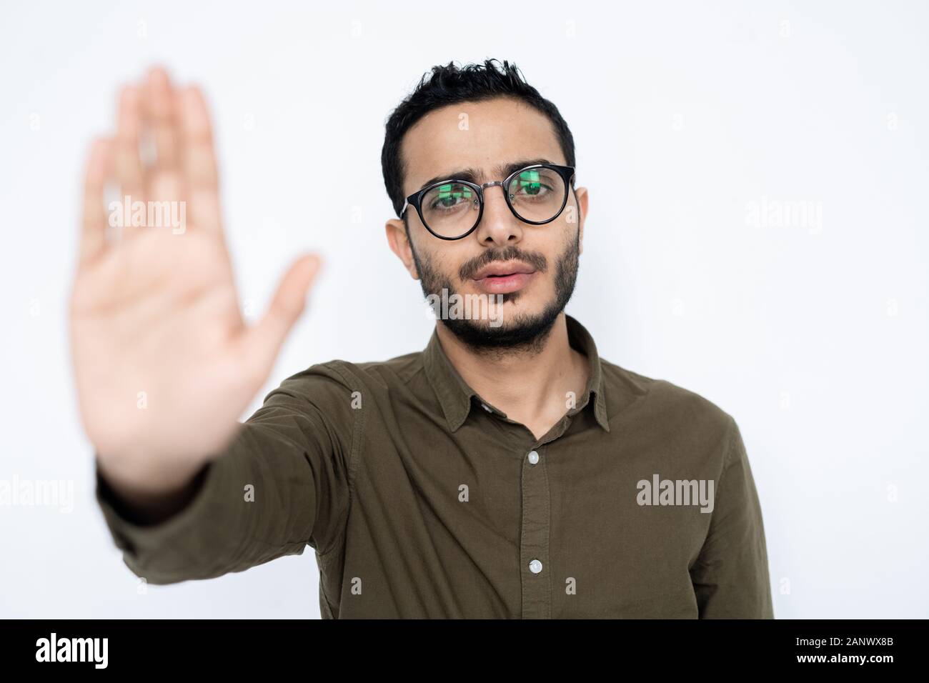 Young man in shirt and eyeglasses showing stop sign to make warning Stock Photo