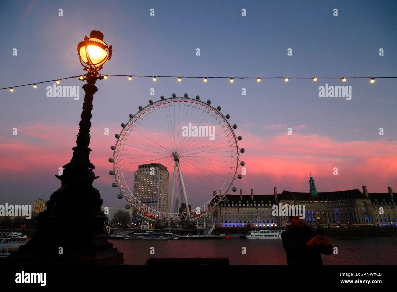 Man taking selfie with London Eye, Shell Centre building and County Hall at sunset, London, England Stock Photo