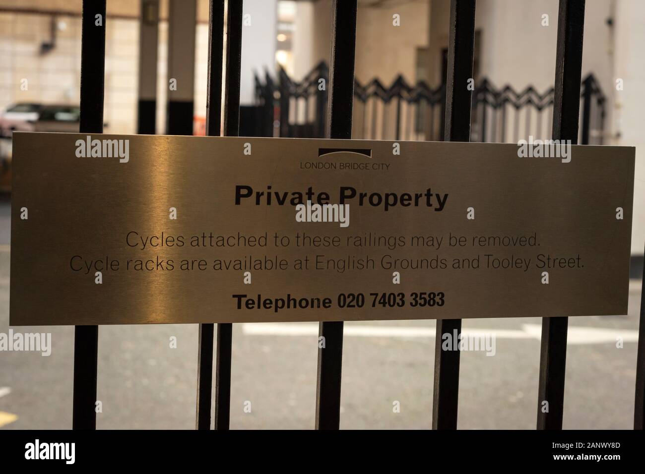 Fancy imposing enamel private property sign on backyard fence by London Bridge City London warning cycles not to be attached to the railings. Stock Photo