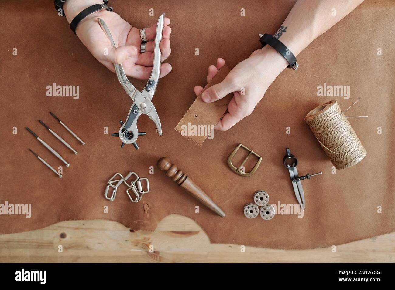 Making holes in leather belt Stock Photo Alamy