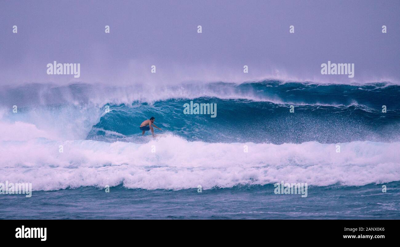 Surfer on big wave in dangerous seas Stock Photo