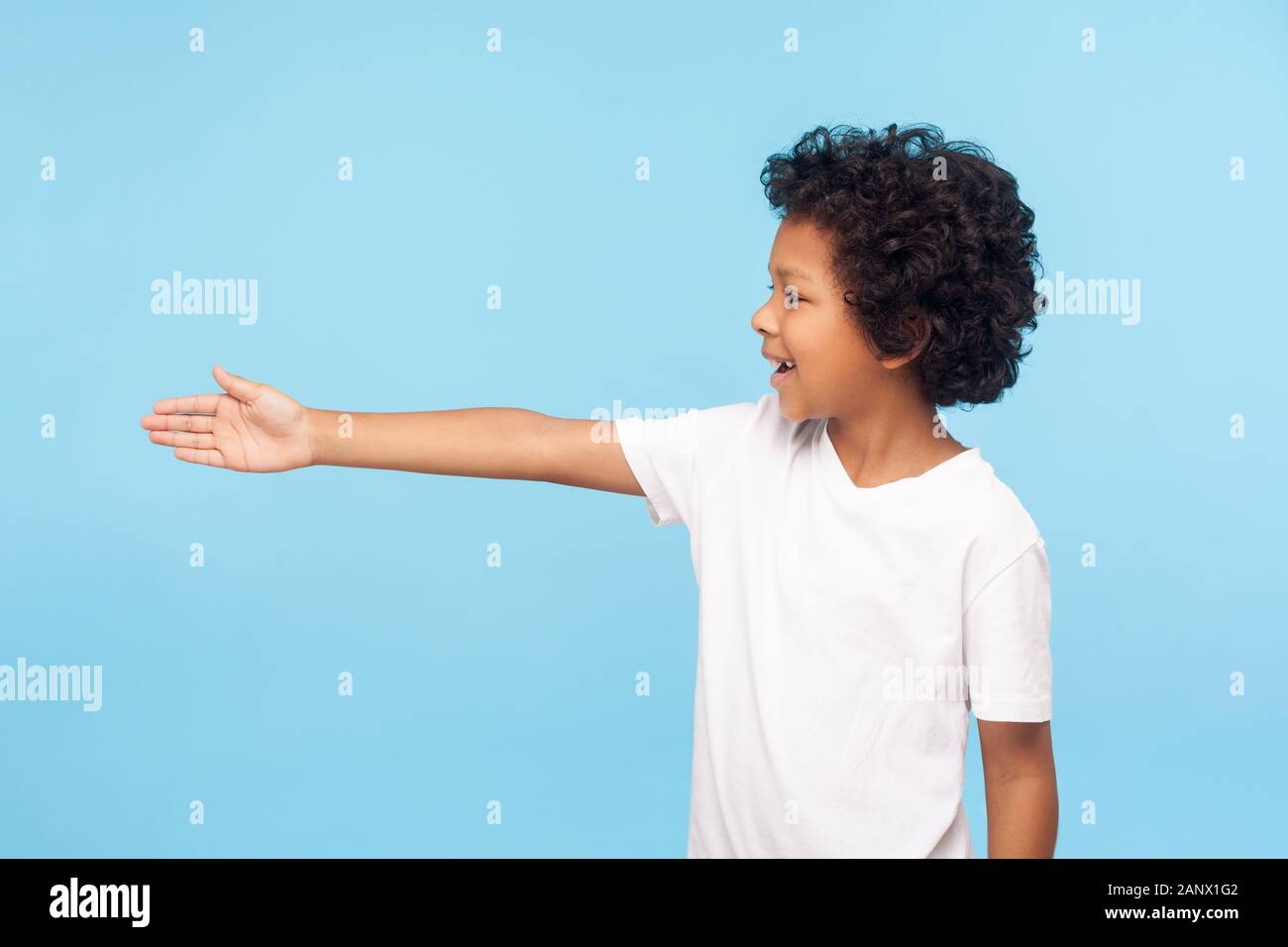 Profile of polite cheerful preschool boy with curly hair in white T ...