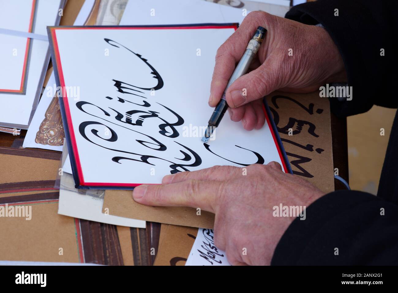 Hüsn-ı Calligraphy. the calligrapher writes arabic writing with calligraphy pen on paper. islamic calligraphy art and workshop. Stock Photo