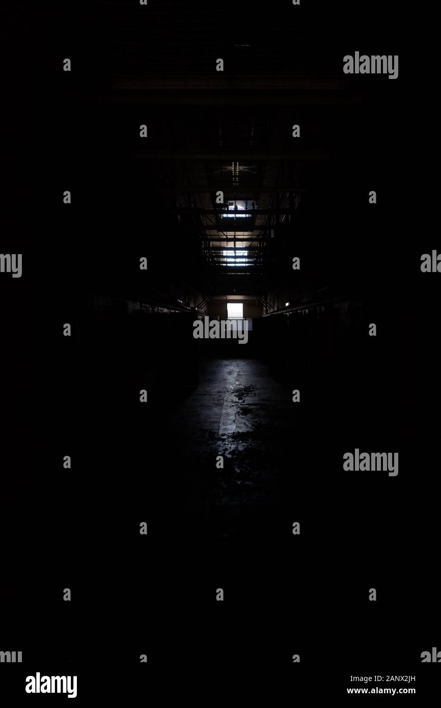 Very dark corridor illuminated only by window light, Parramatta Gaol, Sydney, Australia Stock Photo