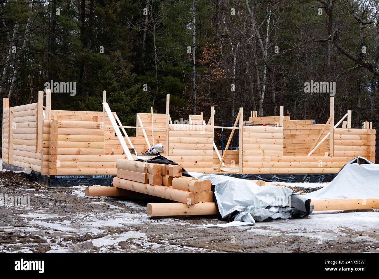 A manufactured prefabricated log home under construction in winter in Speculator, NY USA Stock Photo