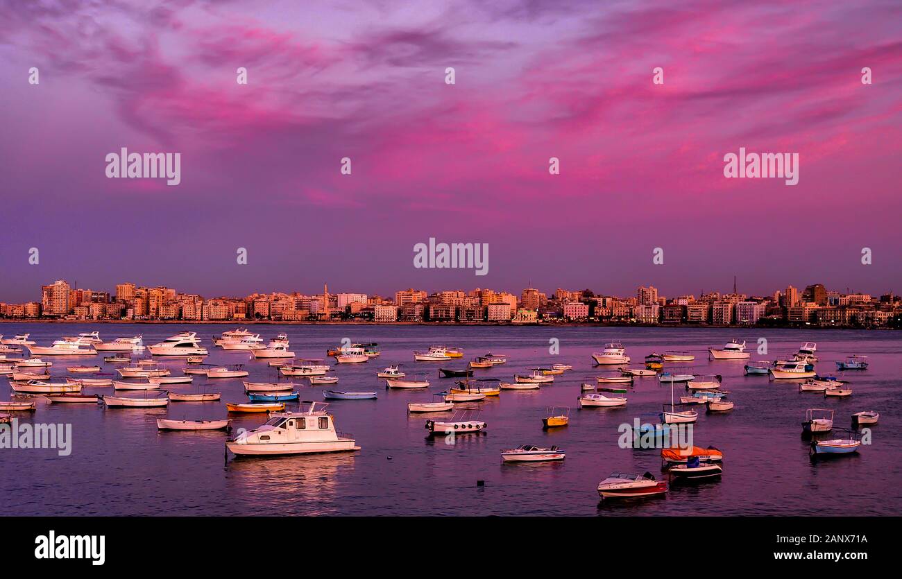 Vibrant colored skies over Stanley Bay fishing fleet at dusk in Alexandria Egypt Stock Photo