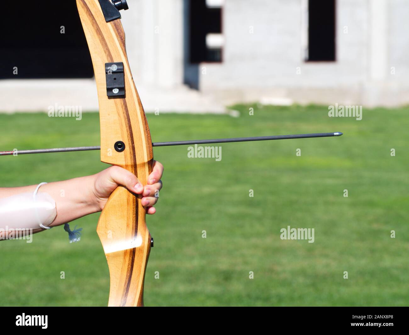archery. bow and arrow. woman is throwing arrow. green background Stock