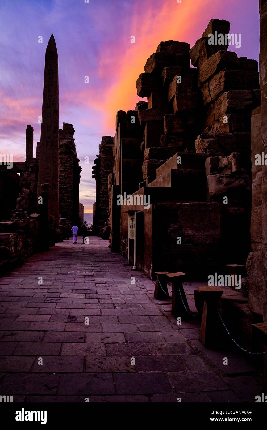 Sun setting behind the Great Hypostyle Hall and Obelisk in the Karnak Temple complex Stock Photo