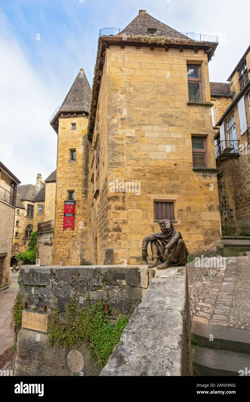 France, Dordogne, Sarlat-la-Caneda, Rue Magnanat, Le Badaud 'The Onlooker' statue of Gerard Badaud by sculptor Gerard Auliac, Manoir de Gisson in back Stock Photo