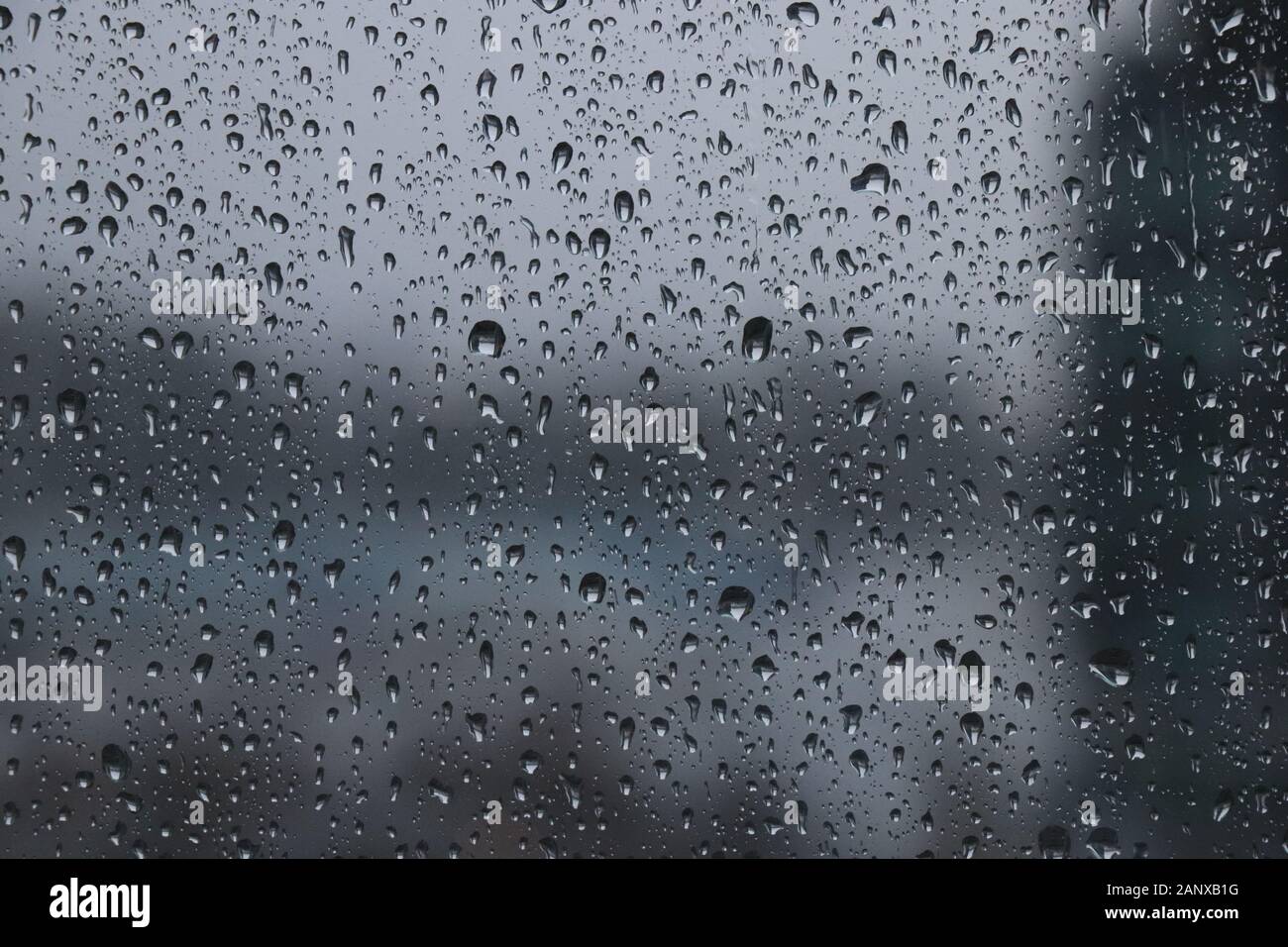 Drops of rain on window during the storm with blur background, dark water  drops background Stock Photo - Alamy