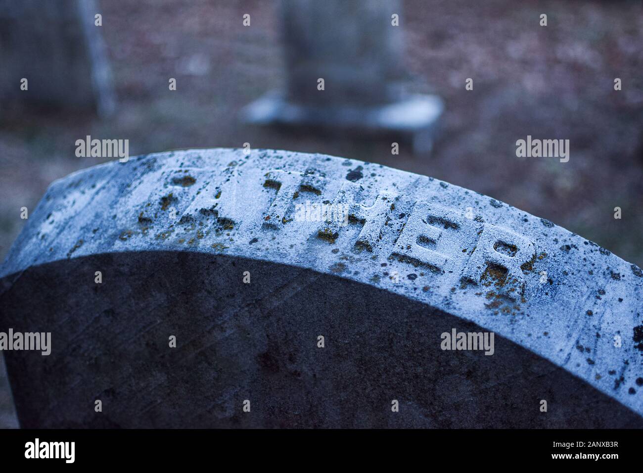 Headstone with the word Father inscribed, at an old dilapidated looking