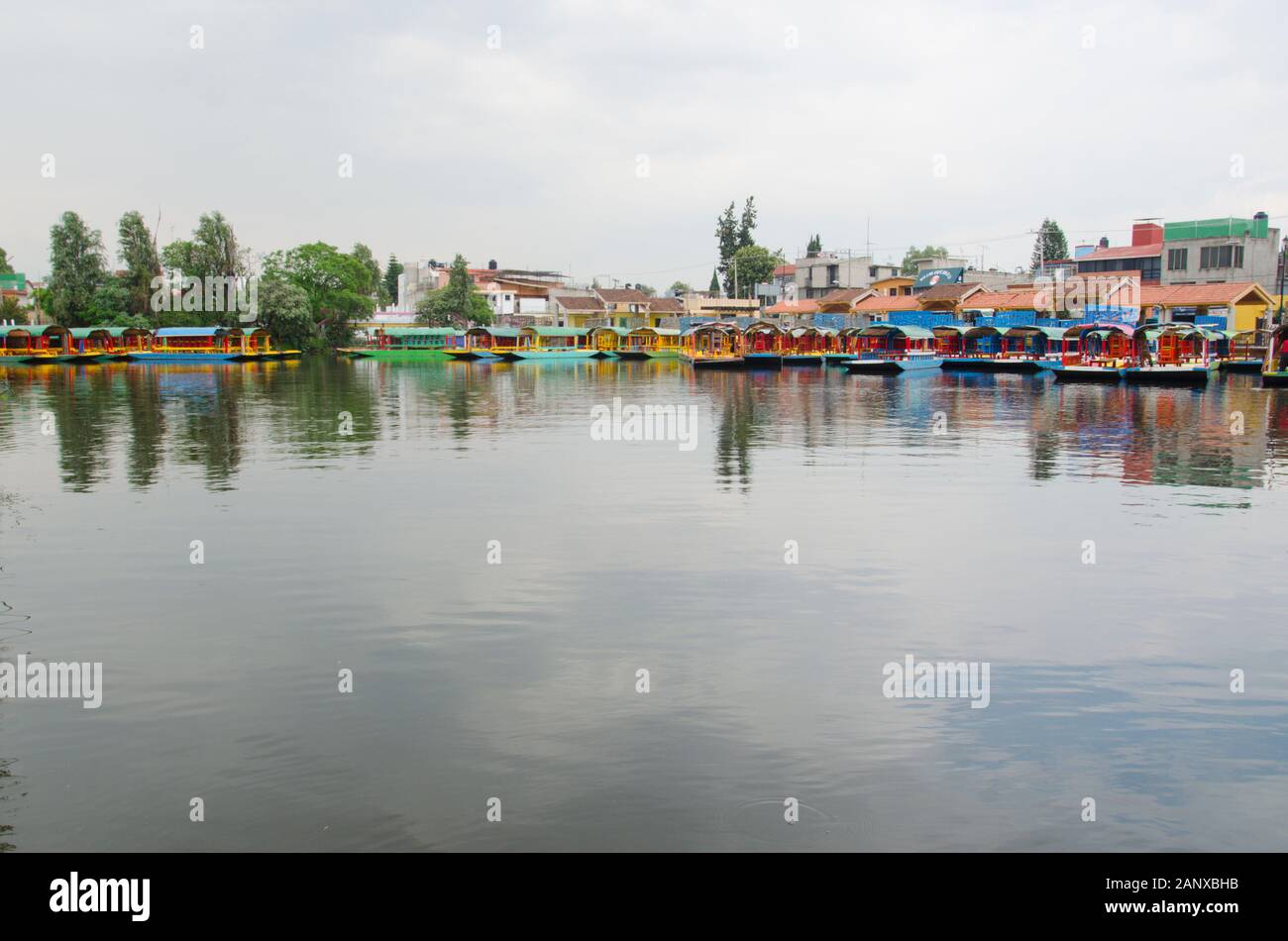 Beautiful scene in Xochimilco, Mexico; trajinera boats on hold and the sky reflected in the water Stock Photo