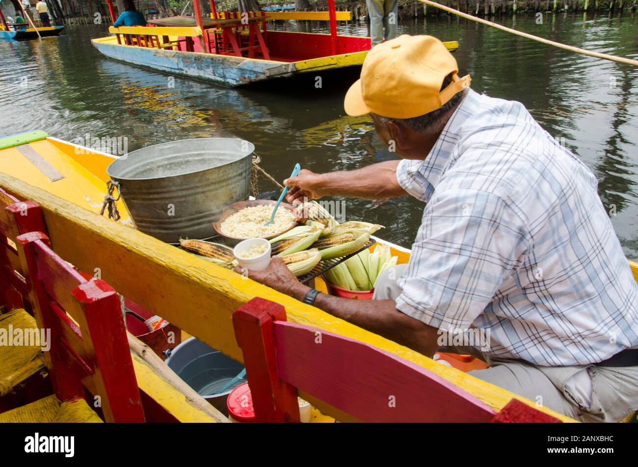 Man preparing esquites and elotes, traditional Mexican corn-based meals ...