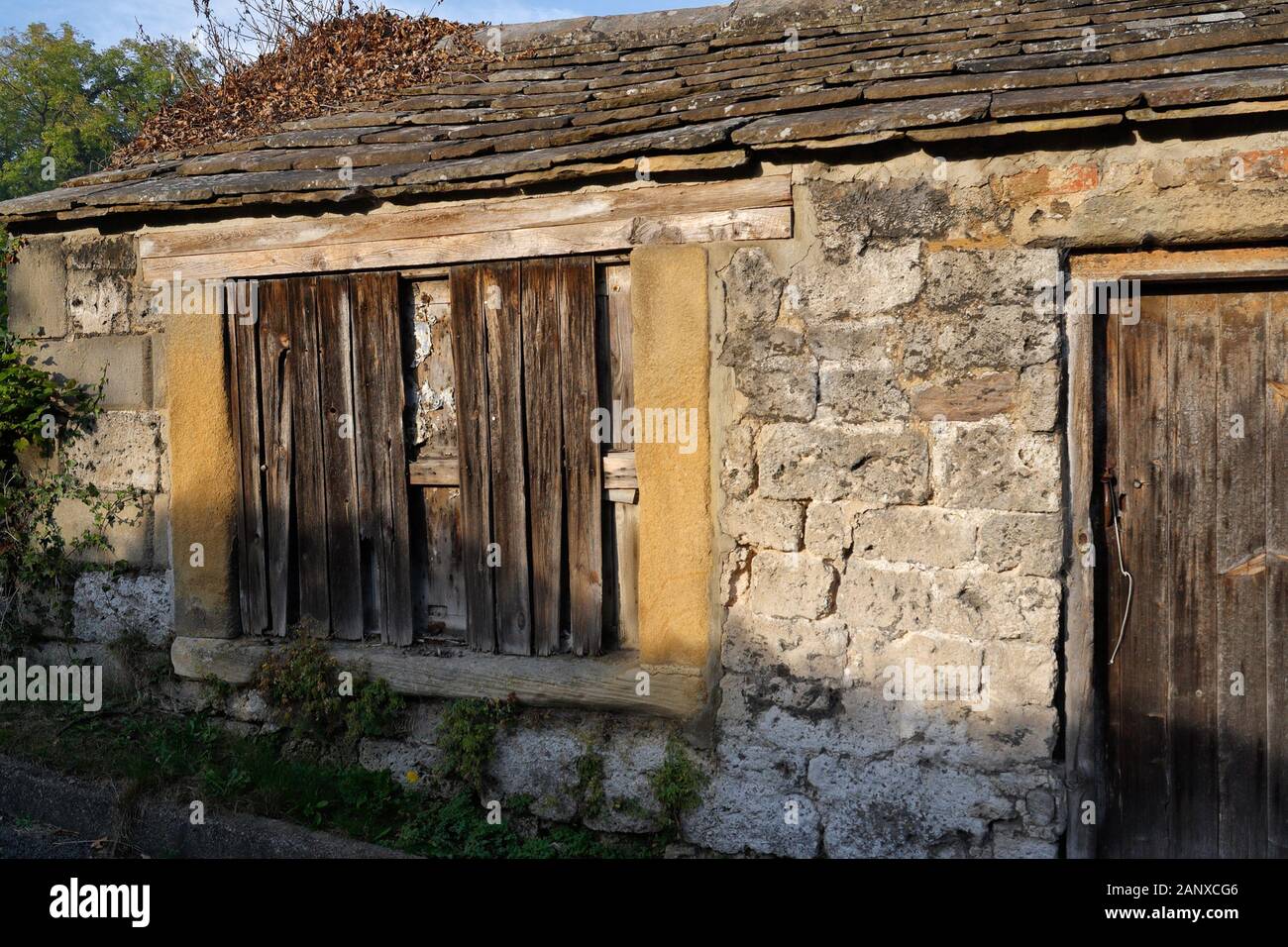 Derelict single storey building, boarded up window. Alport, Derbyshire England Stock Photo