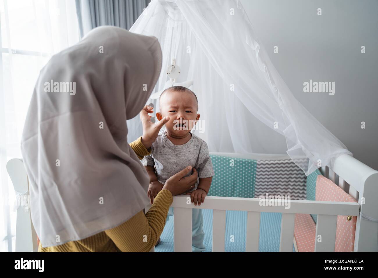 mother looking at her baby boy crying Stock Photo
