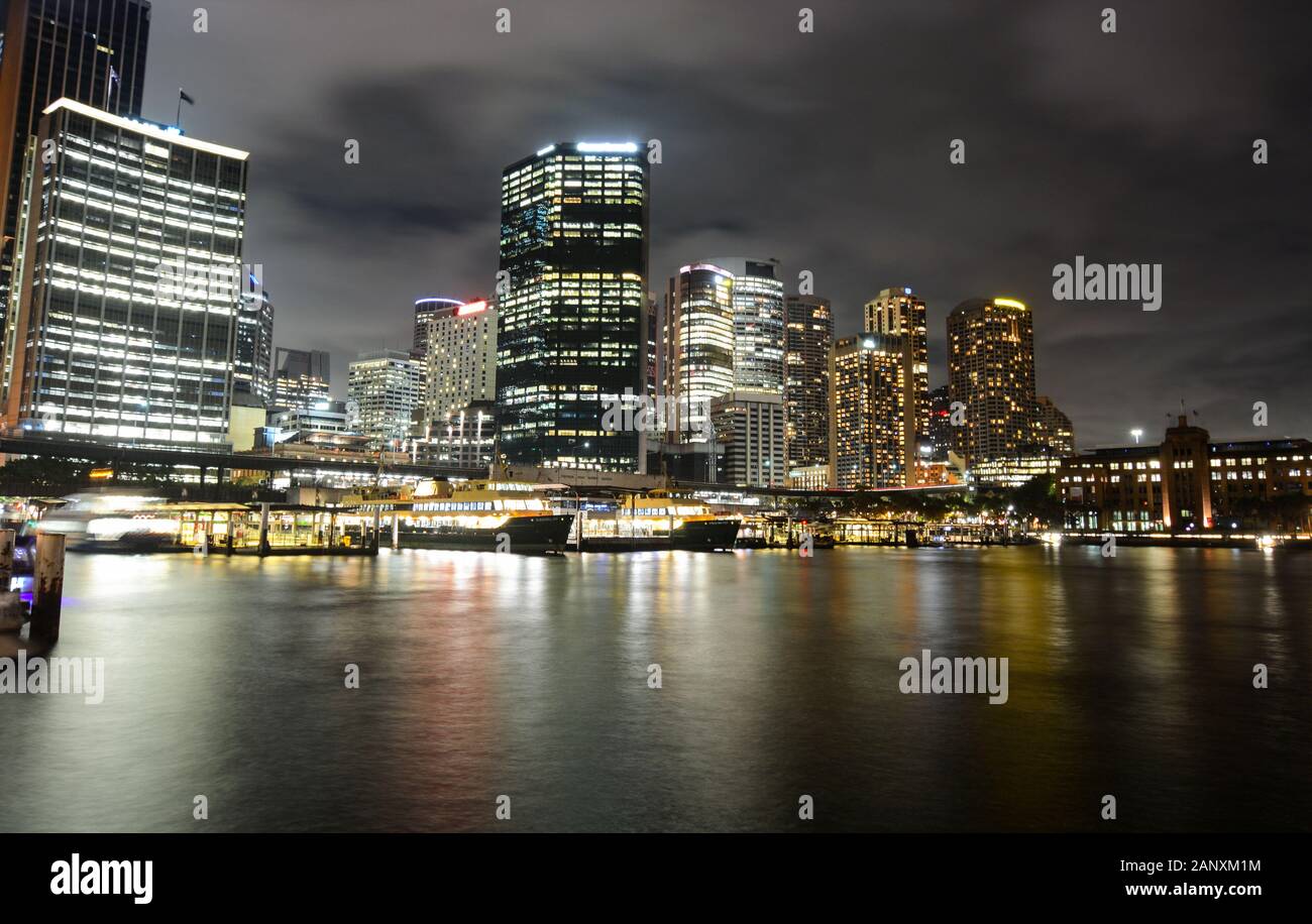 Circular Quay ferry docks in front of the central business district at night in Sydney, Australia Stock Photo
