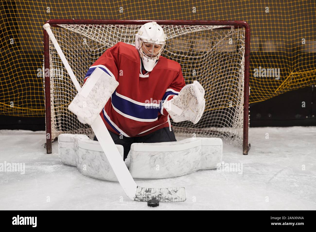 Full length portrait of female hockey player defending gate in full