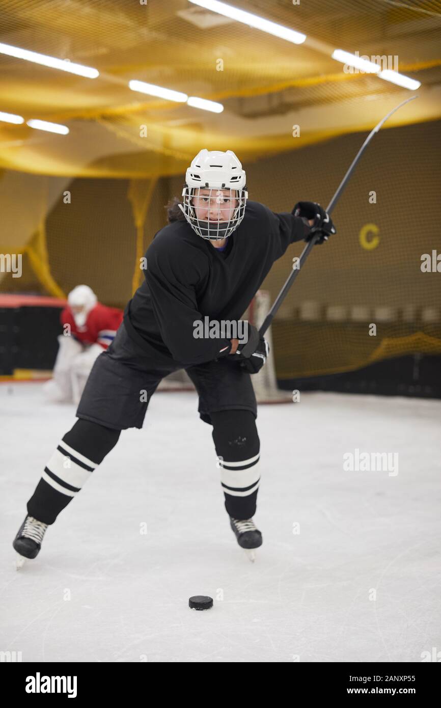 Full length portrait of female hockey player leading pluck during