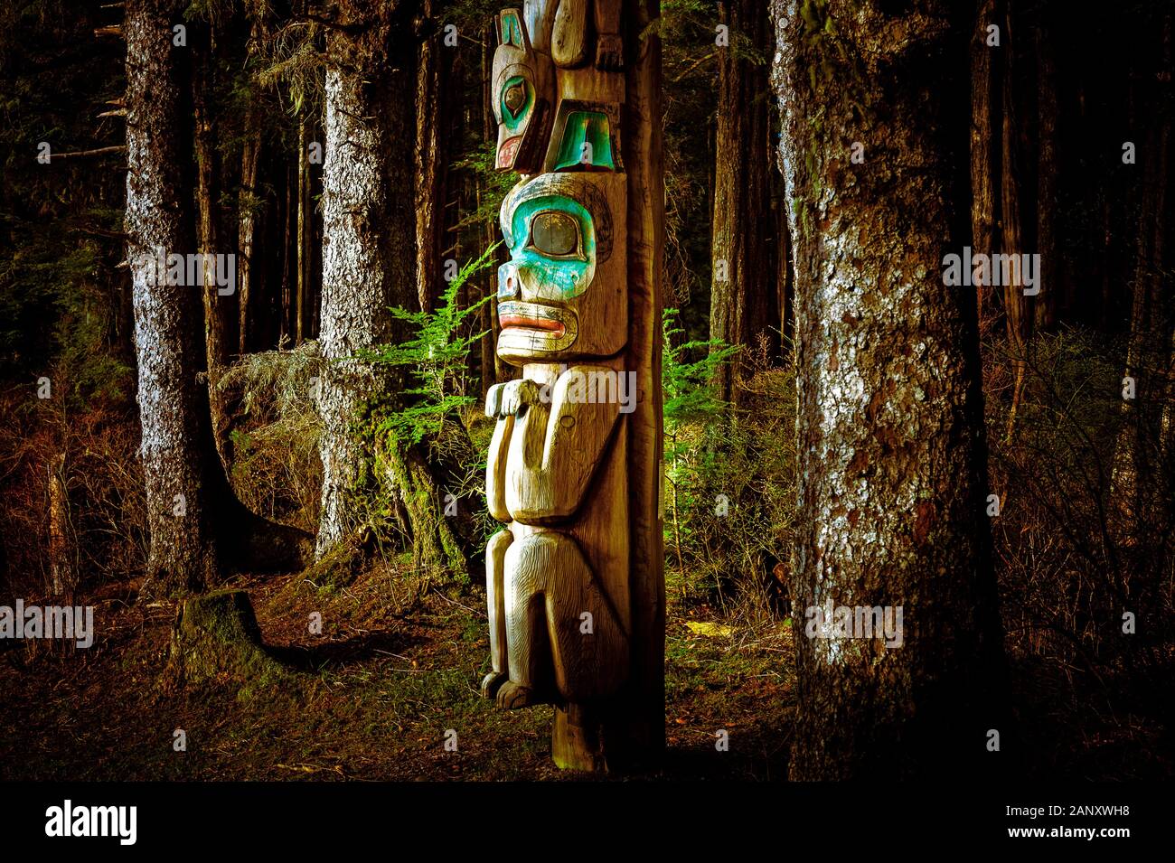 Totem pole beside tourist trail in Sitka National Historical Park in Sitka, Alaska, USA Stock Photo