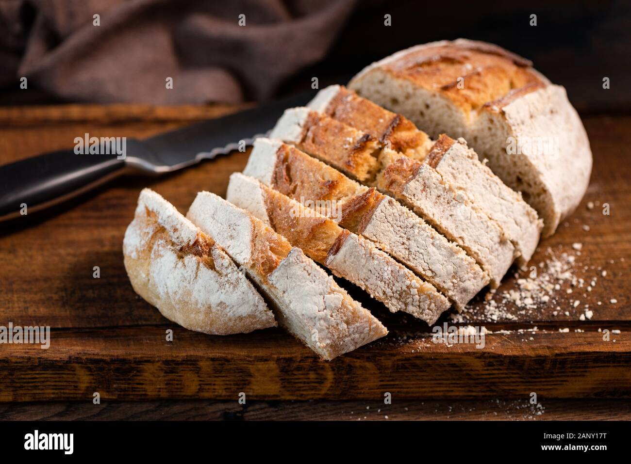 Sourdough white bread sliced on wooden cutting board, closeup view. Wheat bread Stock Photo