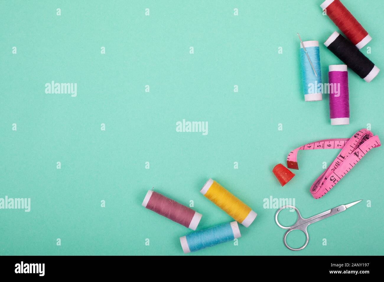 Sewing kit  tools for tailoring and colorful  threads,needles,pins,scissors on mint background mockup frame top view  Stock Photo - Alamy