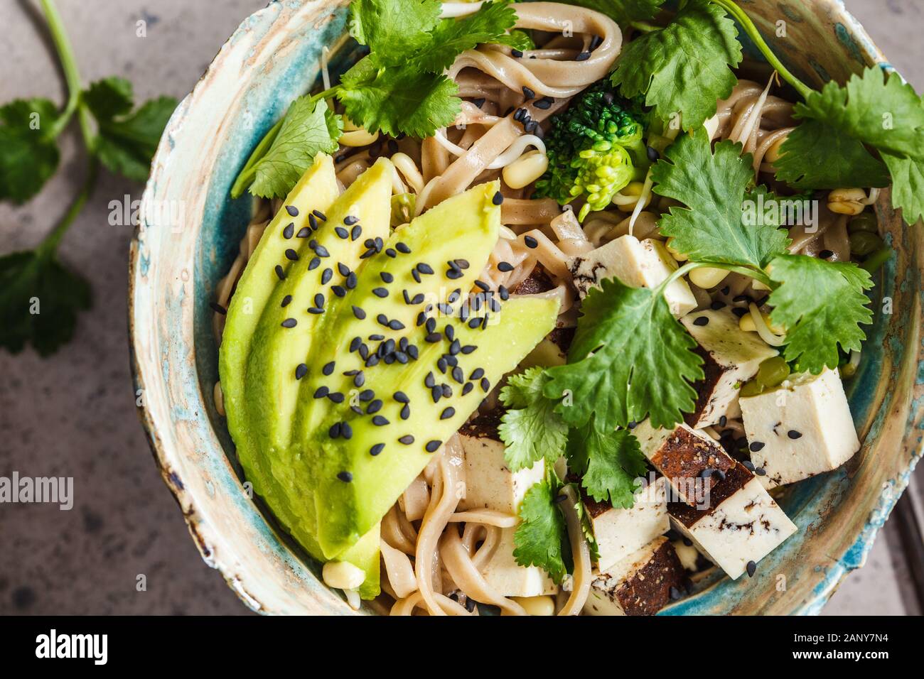 Buckwheat noodles soba with tofu, broccoli, avocado, seedlings and
