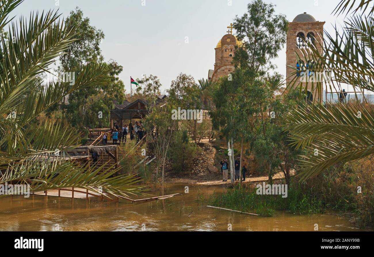 a group of pilgrim tourists gather at the site of the baptism of jesus on the recently flooded jordan river Stock Photo