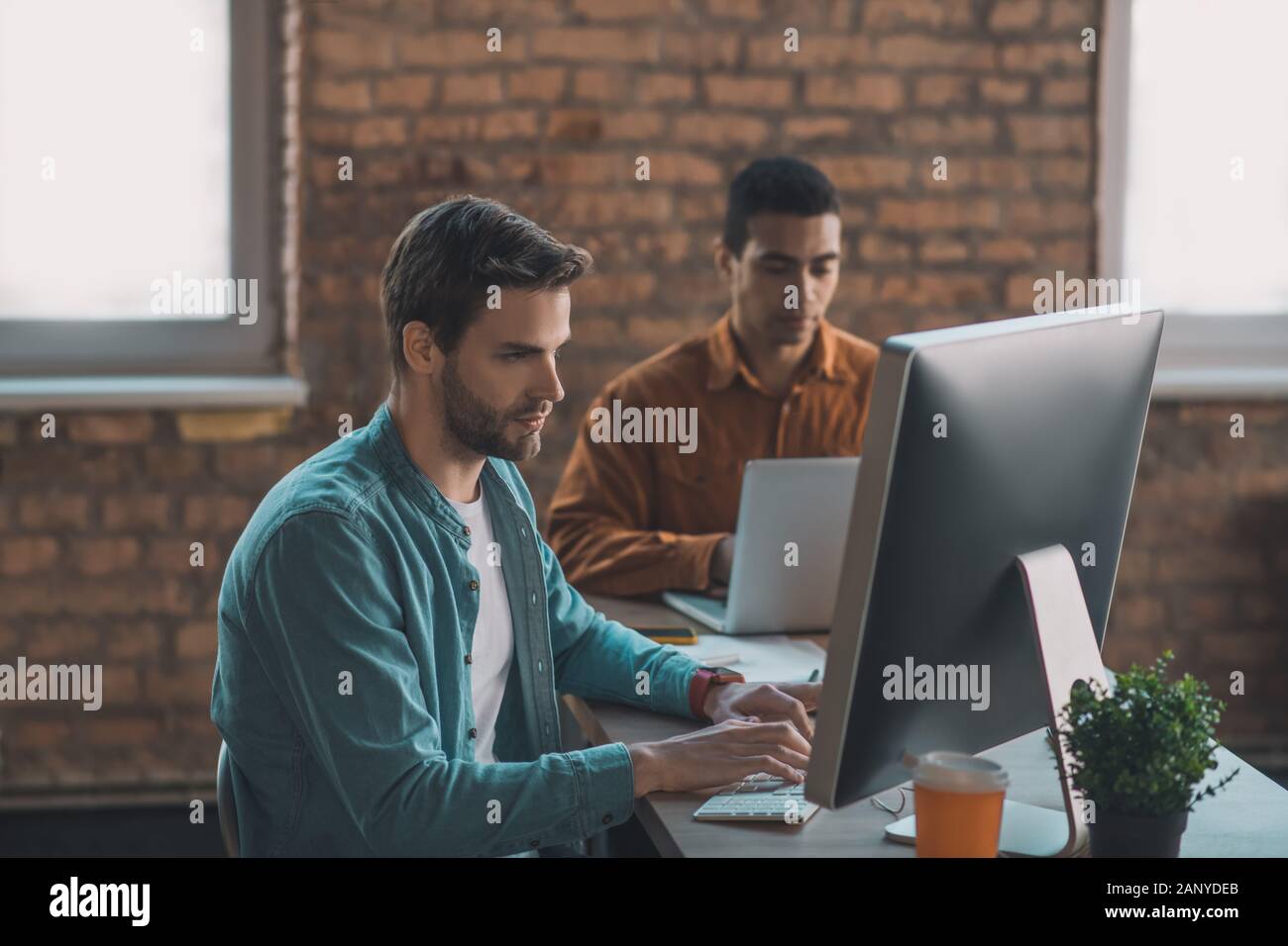 Serious good looking man typing on the keyboard Stock Photo