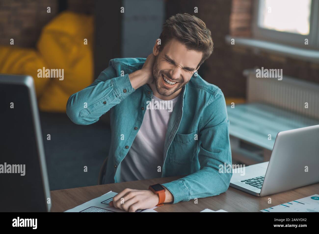 Good looking young man touching his neck Stock Photo - Alamy