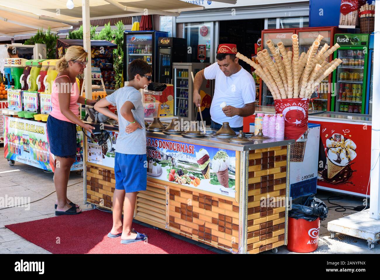 Antalya, Turkey - July 26, 2019: Ice cream Seller in Turkey in Antalya puts ice cream to a boy and a woman in sunny day Stock Photo