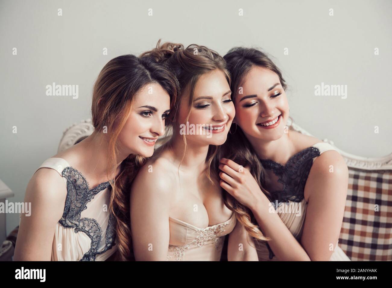 happy bride with her two friends sitting on the couch . Stock Photo