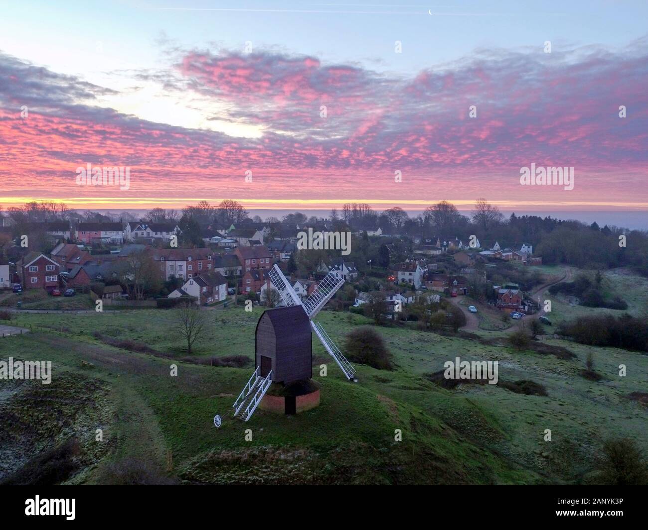 The sun rises over the village of Brill near Aylesbury in Buckinghamshire. The Grade II* listed windmill dates back to the 17th century. Stock Photo