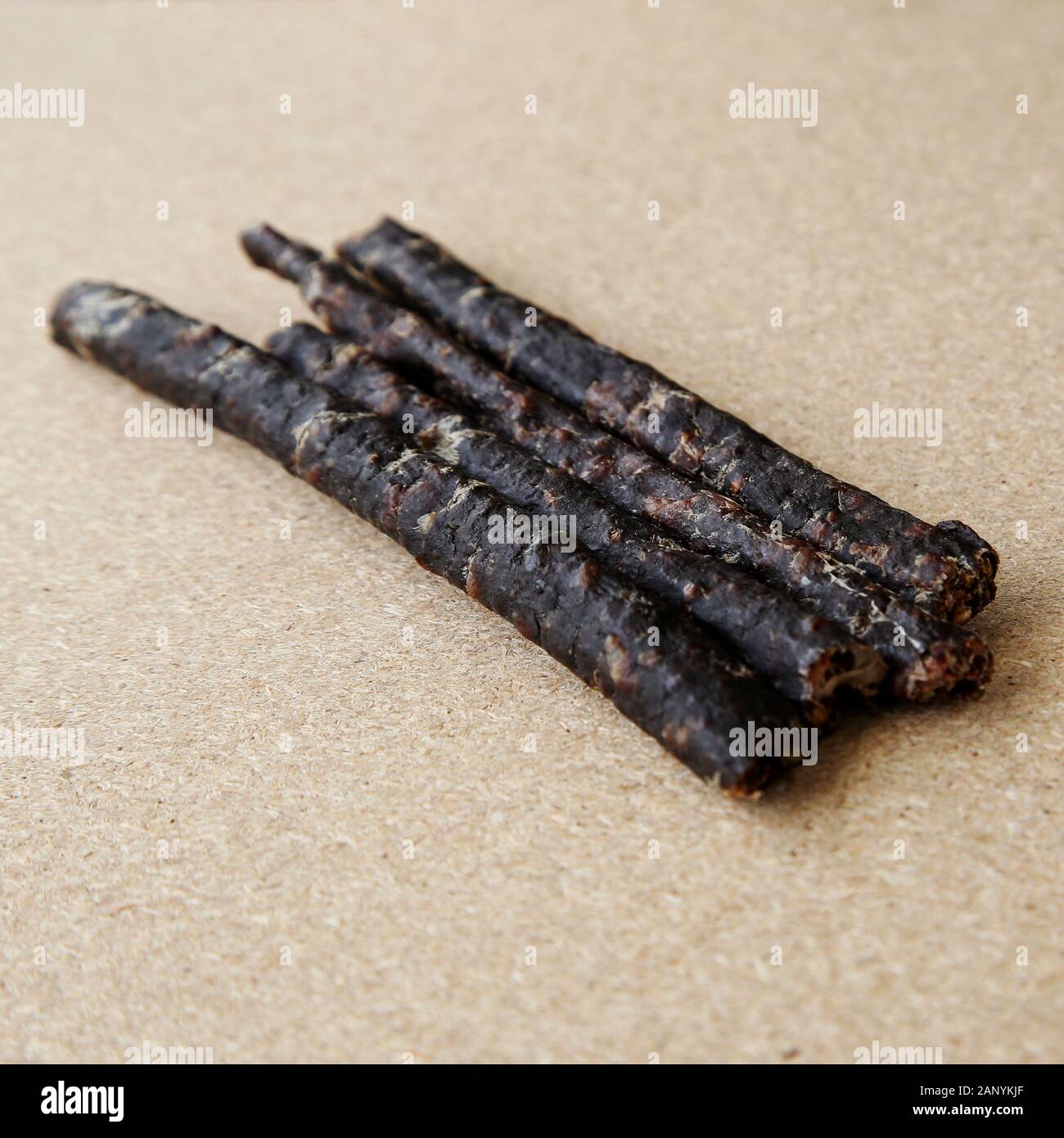 Sticks of traditional African droewors on a wooden surface Stock Photo