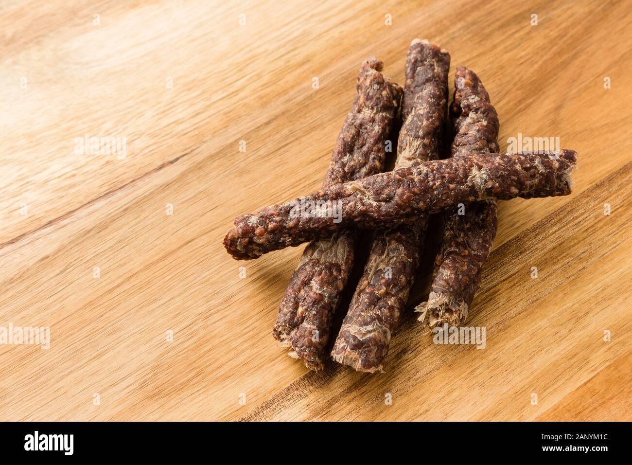Sticks of traditional African droewors on a wooden surface Stock Photo