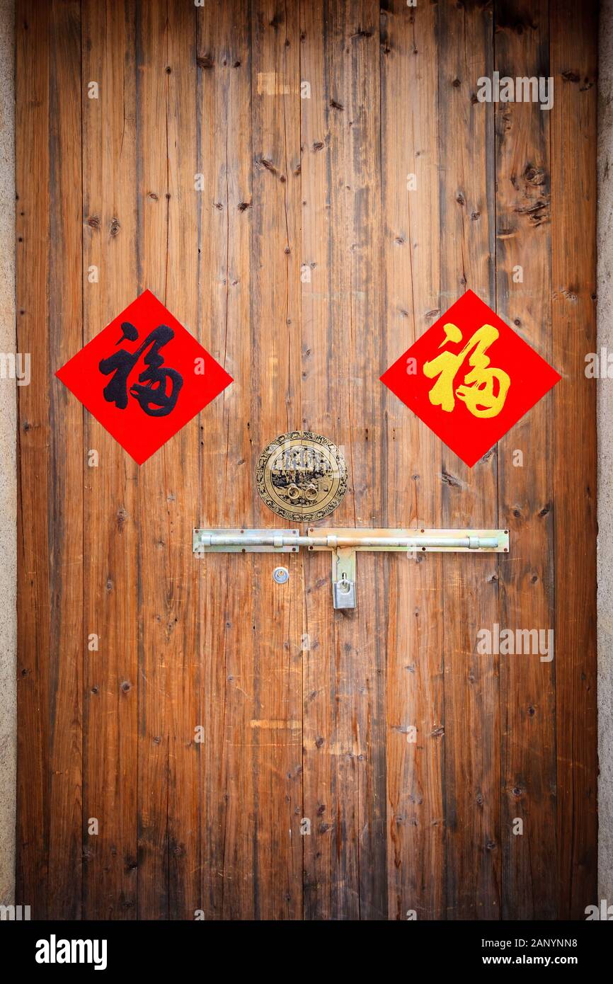 Two colorful Chinese blessing 'Fu' on the  traditional chinese  wooden door with handle and padlock. The 'Fu' with red background, luck and happiness Stock Photo