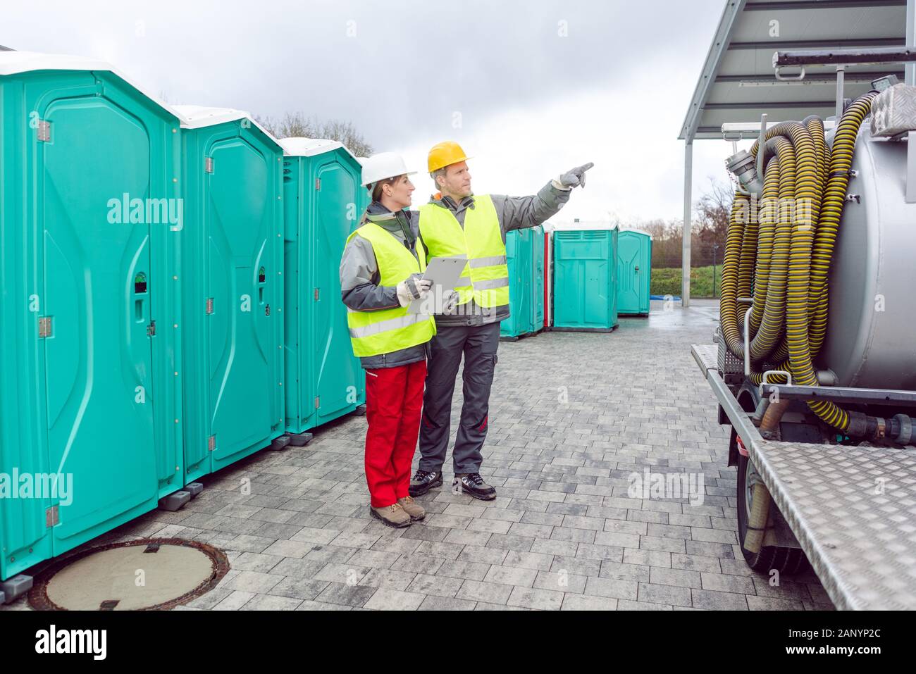 Workers inspecting mobile toilet before shipment Stock Photo