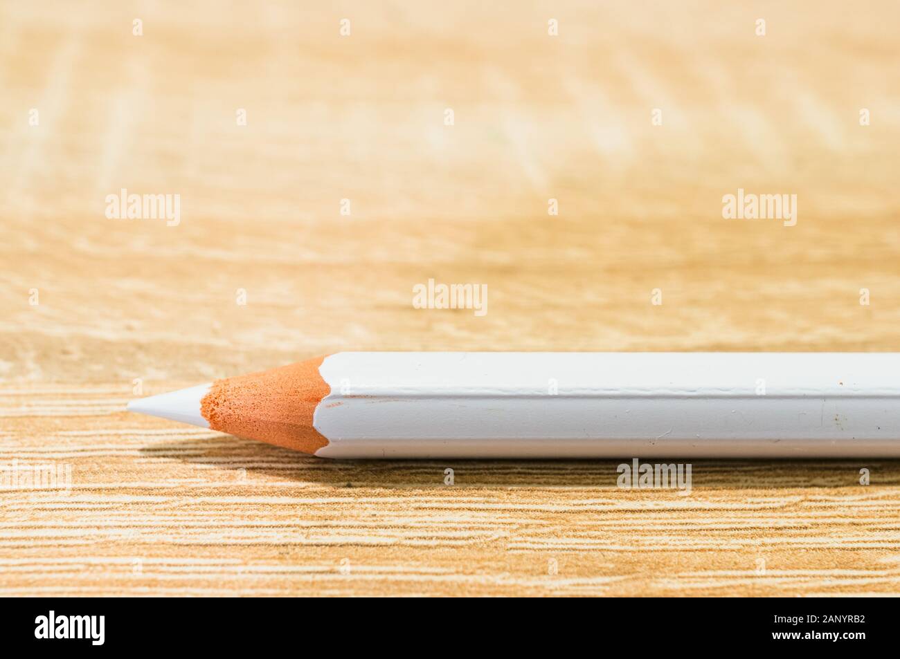 Closeup shot of a white pencil on a wooden surface Stock Photo