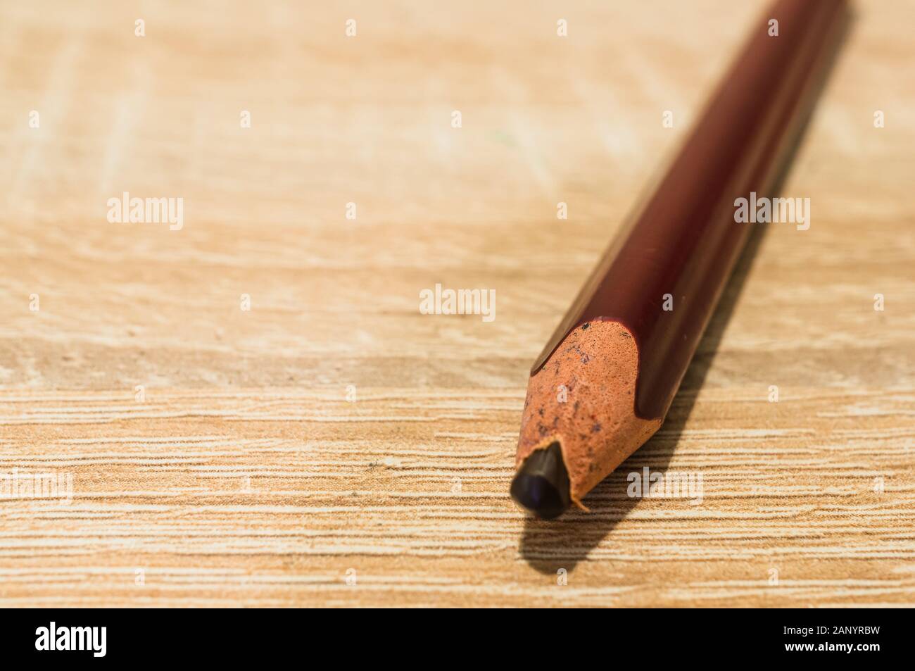 Closeup shot of a brown pencil on a wooden surface Stock Photo