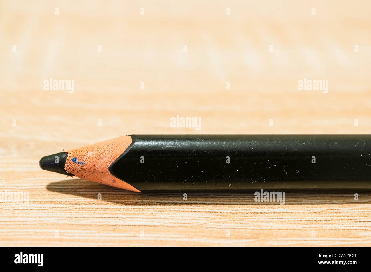 Closeup shot of a black pencil on a wooden surface Stock Photo