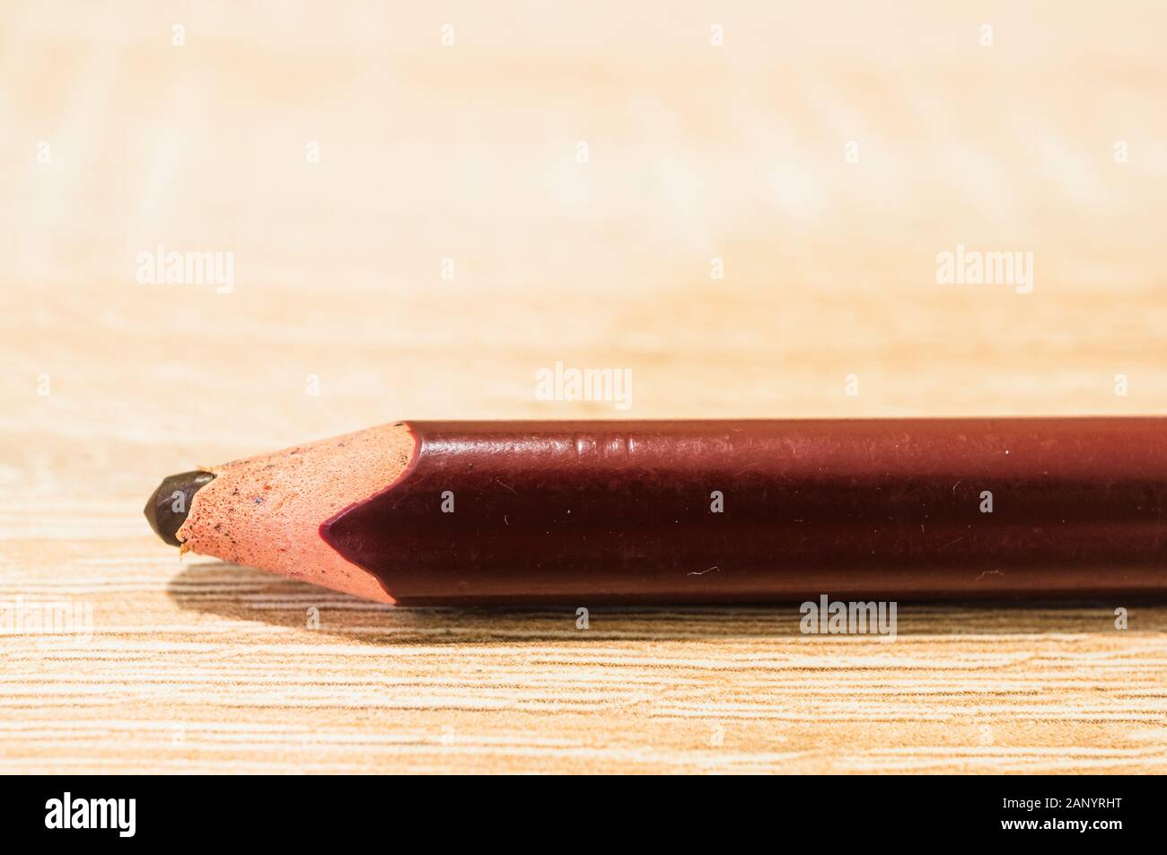 Closeup shot of a brown pencil on a wooden surface Stock Photo