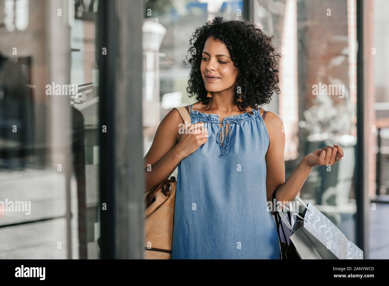 Stylish young woman smiling while out shopping for clothes Stock Photo