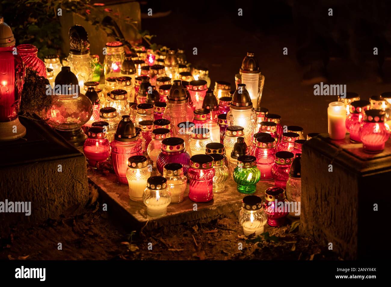 Candle grave lights at night in cemetery on the All Saints Day, Christian tradition. Stock Photo